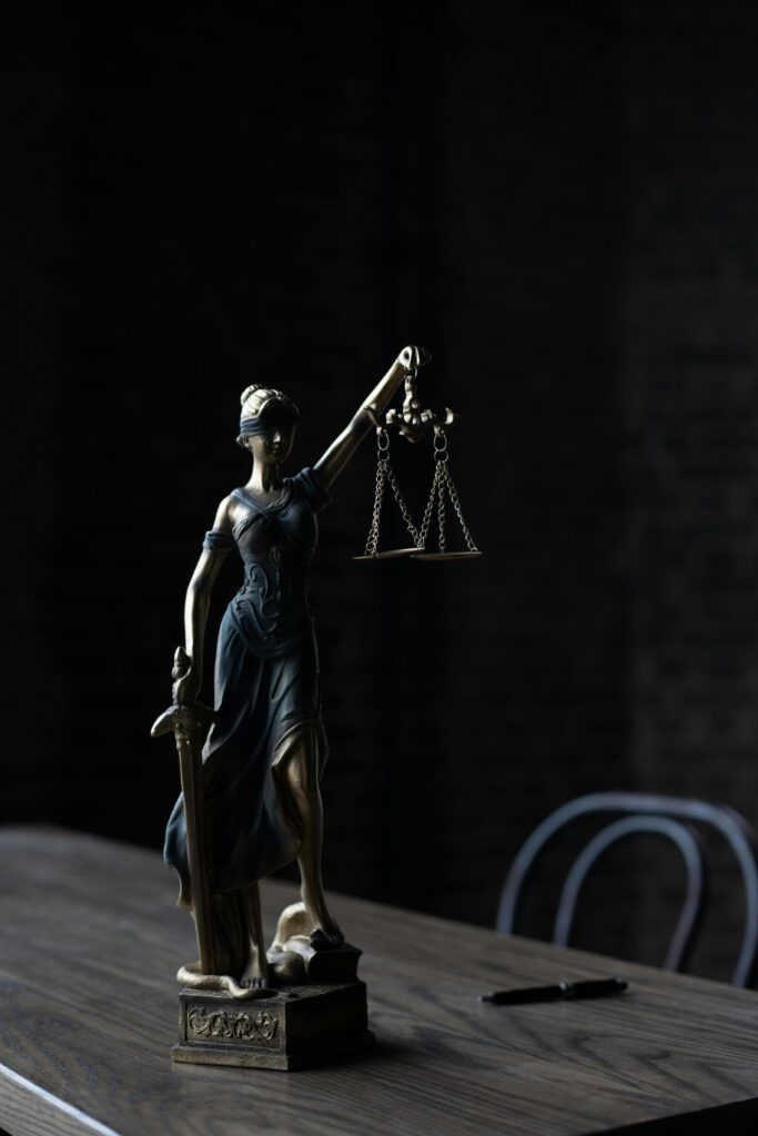 Dramatic lighting on Lady Justice figurine, symbolizing law and fairness.